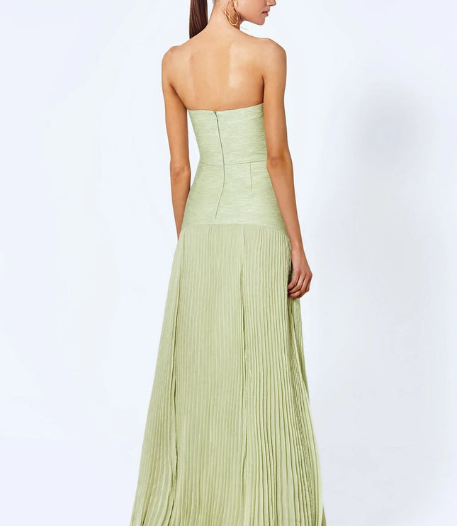 Back view of a women's light green strapless pleated maxi dress showing the flowing skirt and back zipper closure.