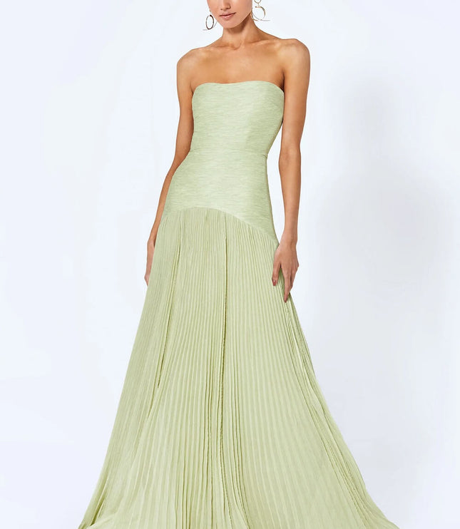 Full-length view of a women's formal strapless pleated maxi dress in a light sage green color, flowing skirt.