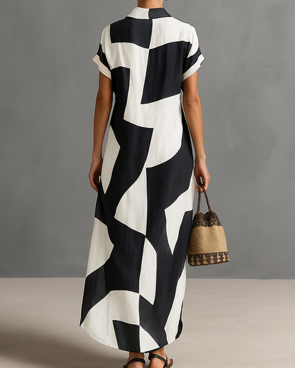 Back view of a women's black and white geometric print maxi dress with short sleeves, showcasing the full length and pattern.