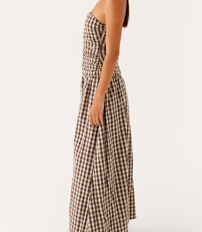Profile view of women's brown and white gingham strapless maxi dress, ruched detail