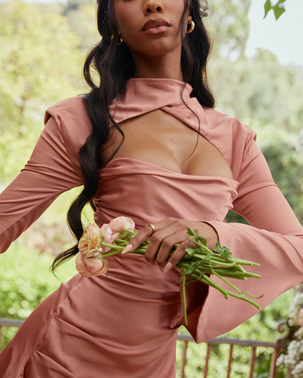 Close-up front view of the dusty rose halter cut out mini dress, highlighting the neckline, ruched detail, and long flared sleeves.
