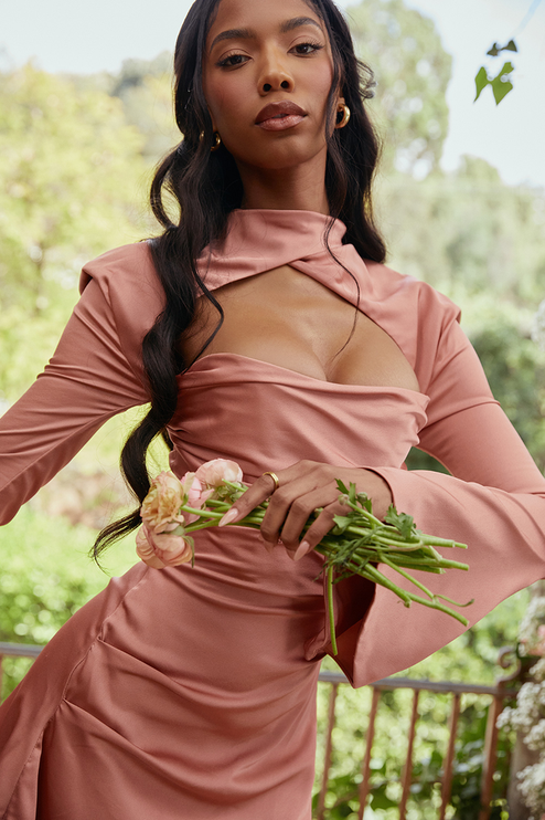Close-up front view of the dusty rose halter cut out mini dress, highlighting the neckline, ruched detail, and long flared sleeves.