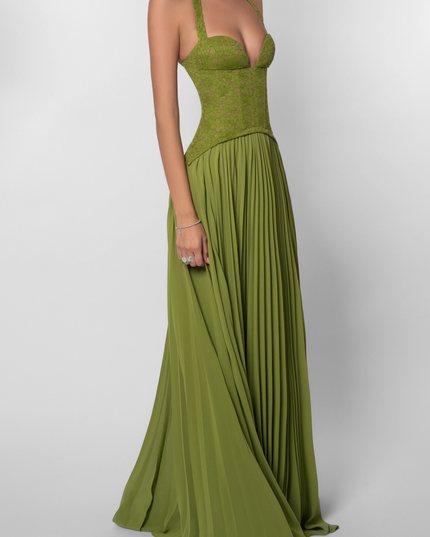 Angled view of the olive green halter dress, showing the deep V-neckline of the lace corset and the movement of the pleated skirt.