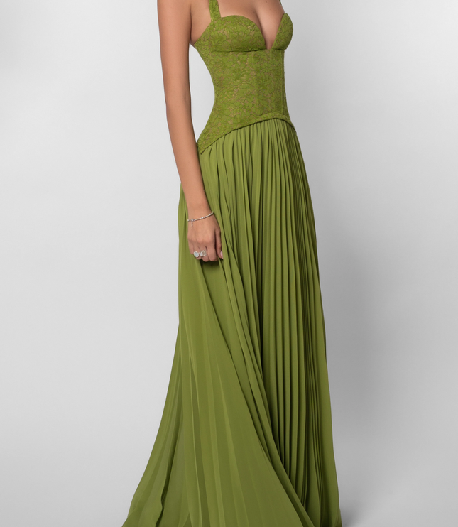 Angled view of the olive green halter dress, showing the deep V-neckline of the lace corset and the movement of the pleated skirt.