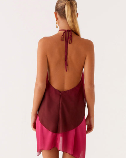 Back view of a women's halter neck ombre layered chiffon mini dress in burgundy and fuchsia, highlighting the open back and tie.