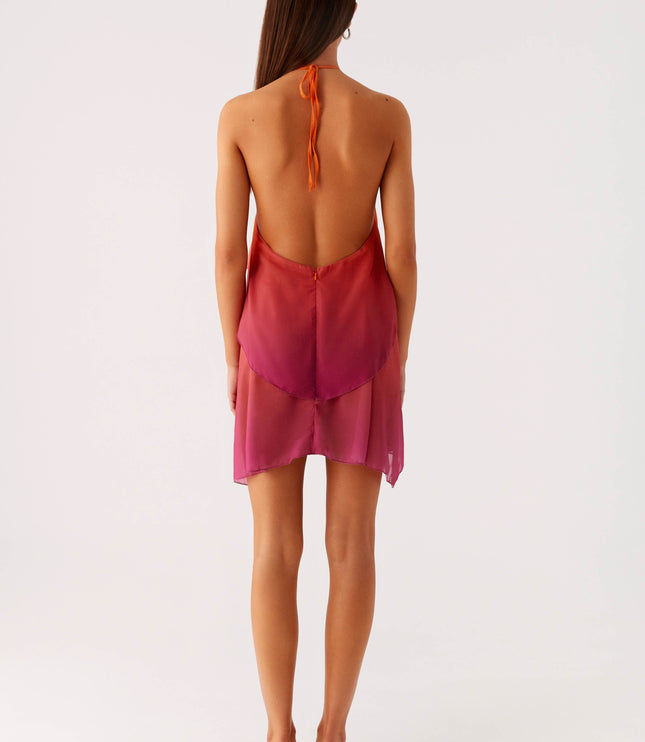 Back view of a women's halter neck ombre layered chiffon mini dress, showing the open back design and tie closure.