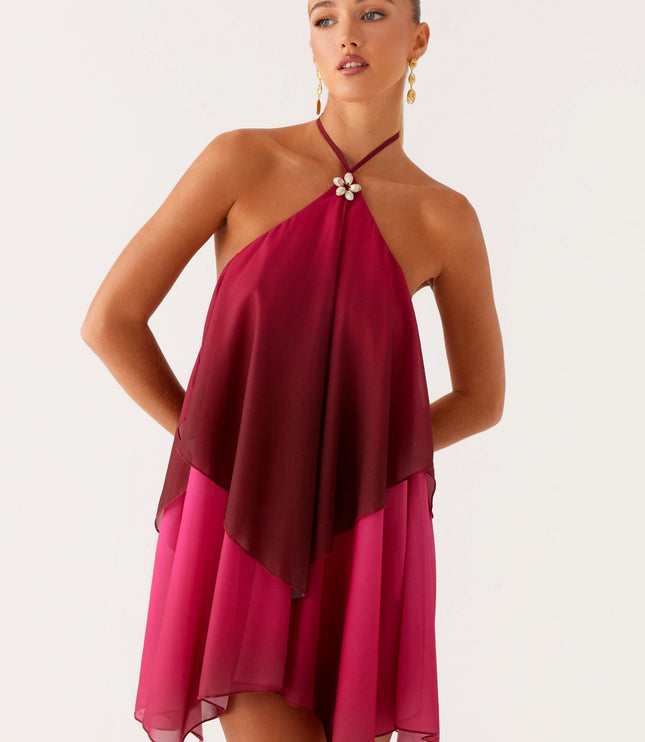 Front view of a women's halter neck layered chiffon mini dress in a rich burgundy and fuchsia ombre, with hands on hips.