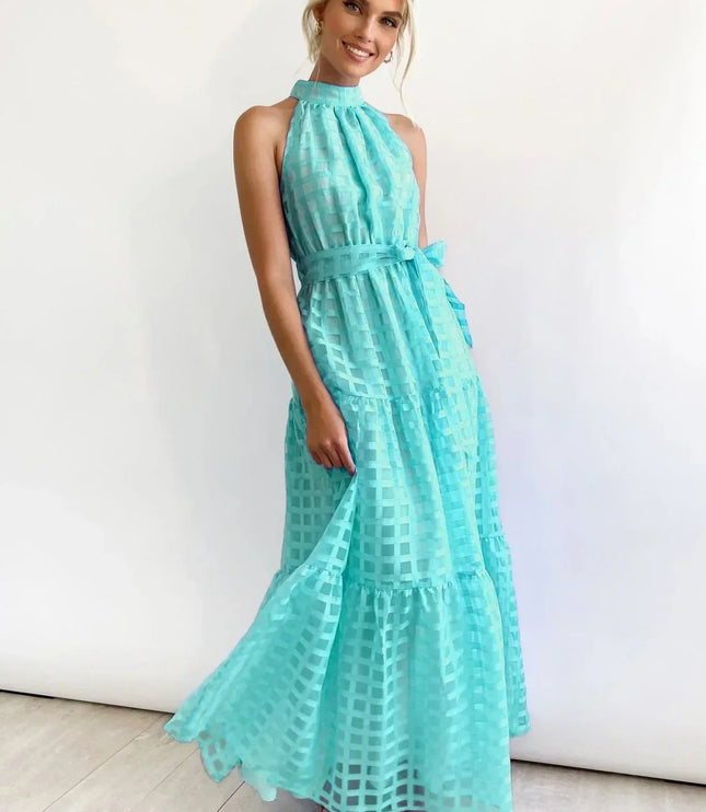 Aqua blue halter neck tiered maxi dress with a checkered pattern and a self-tie belt, twirling gently.