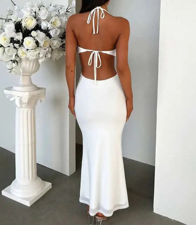 Back view of a white halter ruffle cut out backless maxi dress, showing tie details and a flowing skirt.