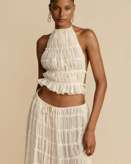 Close-up front view of the women's ivory halter ruffle trim crop top and the top portion of the matching maxi skirt set.