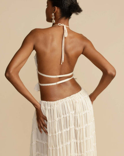 Rear view of the women's ivory halter ruffle trim crop top, showing the tie-back detail, and the matching maxi skirt.