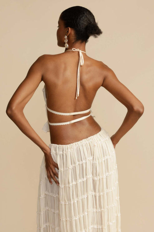 Rear view of the women's ivory halter ruffle trim crop top, showing the tie-back detail, and the matching maxi skirt.