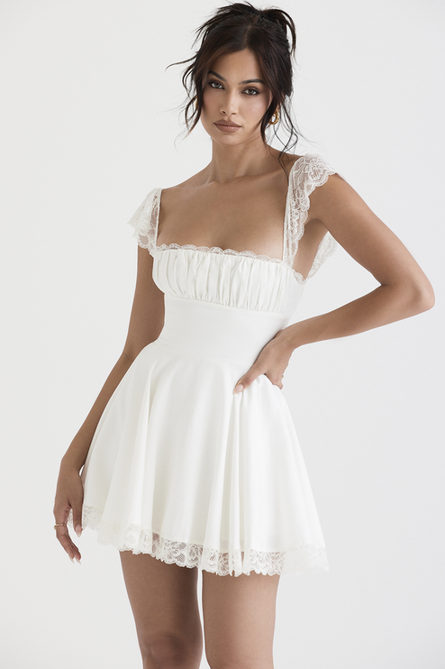 Front view of a white women's mini dress with lace cap sleeves and a square neck, featuring a ruched bust and lace trim on the hem.