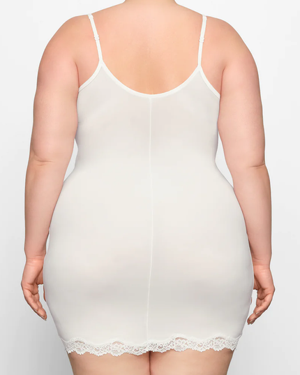 Back view of a plus-size woman in the ivory lace trim scoop neck mini slip dress, showing the full coverage and lace hem.