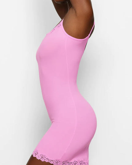 Dynamic side view of the pink lace trim mini slip dress, showing the garment's stretch and fit.