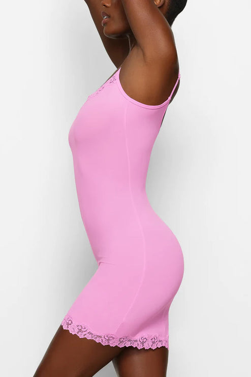 Dynamic side view of the pink lace trim mini slip dress, showing the garment's stretch and fit.