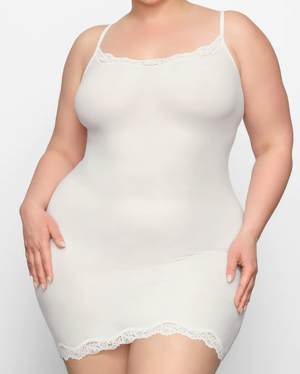 Front view of a plus-size woman wearing an ivory lace trim scoop neck mini slip dress, highlighting the comfortable fit.