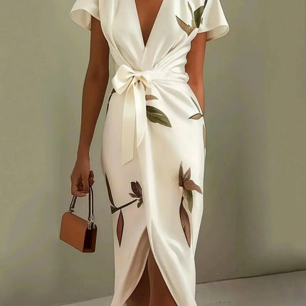 Women's white leaf print v-neck short sleeve midi wrap dress with a tied waist, holding a brown purse.