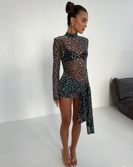 Side profile of women's dark leopard print high neck ruched mini dress with sheer long sleeves and clear heels.