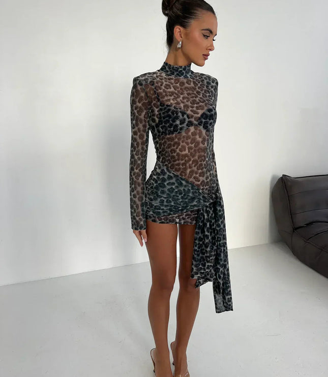 Side profile of women's dark leopard print high neck ruched mini dress with sheer long sleeves and clear heels.
