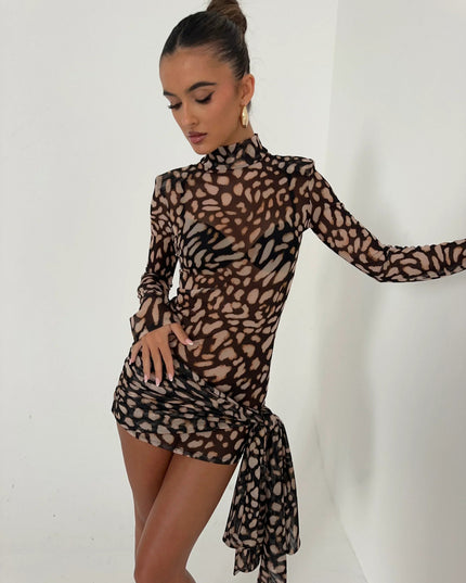 Women's leopard print high neck ruched mini dress with long sleeves and cascading fabric detail, side view.