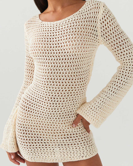 Detail shot of the cream long sleeve crochet mini dress, highlighting the open knit and texture of the fabric.