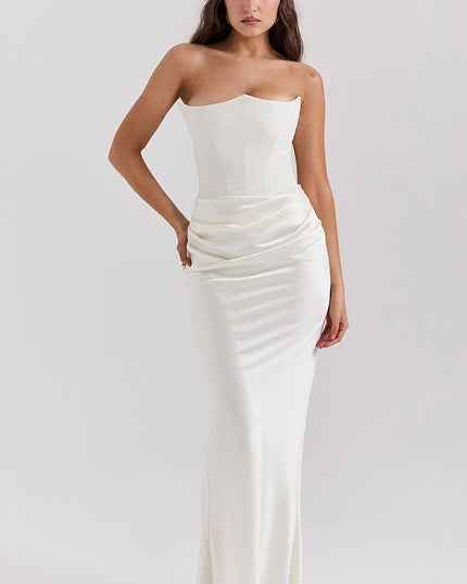 Full-length view of a woman wearing a white off-shoulder bustier draped maxi dress with a sweetheart neckline.