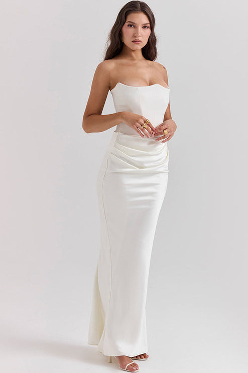 Front view of a white off-shoulder bustier dress, featuring a fitted bodice and gracefully draped skirt detail.