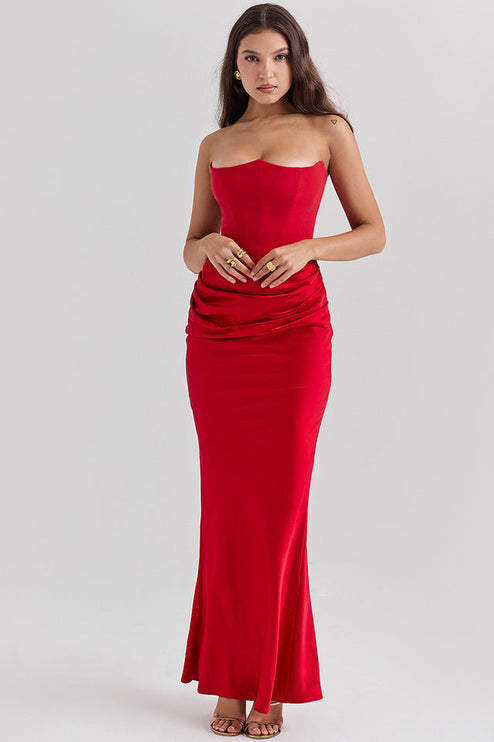 Front view of a red off-shoulder bustier maxi dress with hands clasped, highlighting the fitted bustier and flowing skirt.