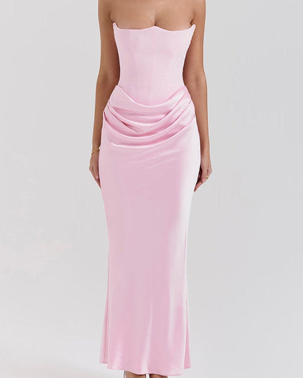 Front view of a women's off-shoulder bustier draped maxi dress in a soft pink, with a structured bodice.