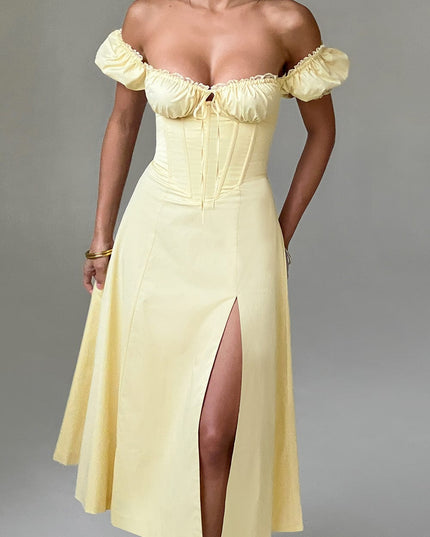 Studio shot, front view of a light yellow off-shoulder puff sleeve corset midi dress with a thigh-high split.
