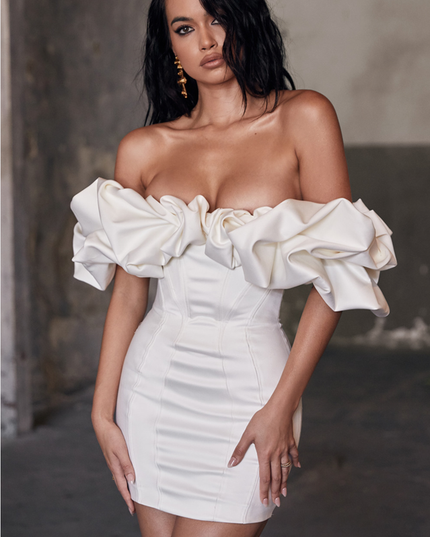 Elegant off-shoulder satin mini dress in creamy white with dramatic ruffled sleeves and a structured bodice.