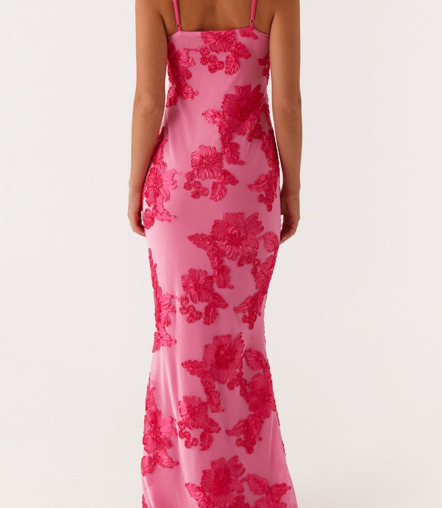 Back view of a women's pink floral maxi dress featuring intricate embroidered flowers and thin shoulder straps.