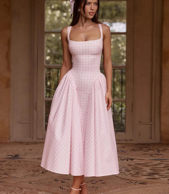 Women's pink gingham square neck midi dress with full pleated skirt, styled with pink heels and hair bow