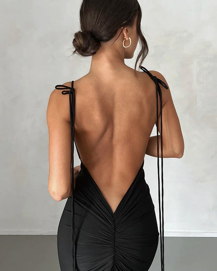 Detailed back view of a black pleated plunge neck backless maxi dress, highlighting the ruching and tie straps