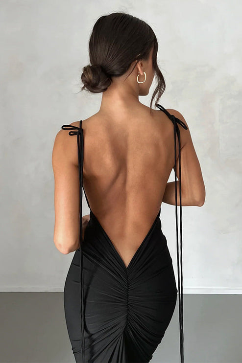 Detailed back view of a black pleated plunge neck backless maxi dress, highlighting the ruching and tie straps