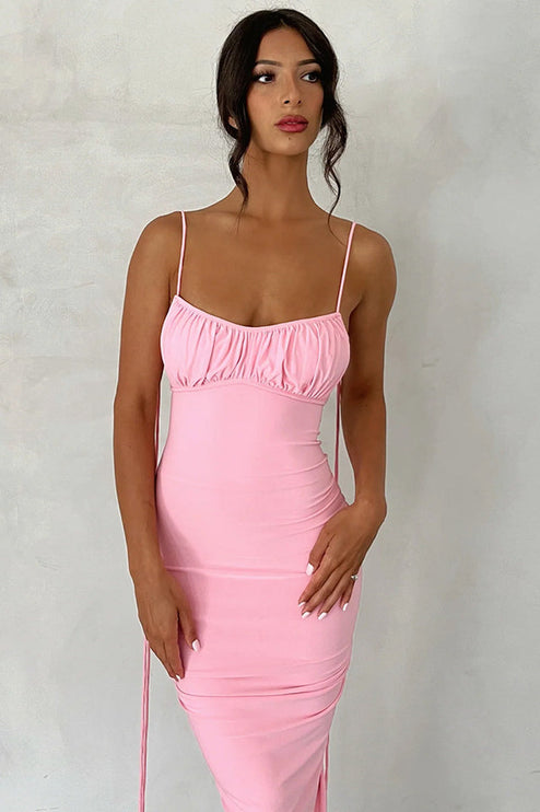 Close-up of a pink pleated plunge neck maxi dress, featuring the ruched bust and side details