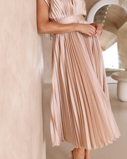 Women's light pink pleated v-neck midi dress, with hands clasped, emphasizing the delicate pleats and sophisticated design.