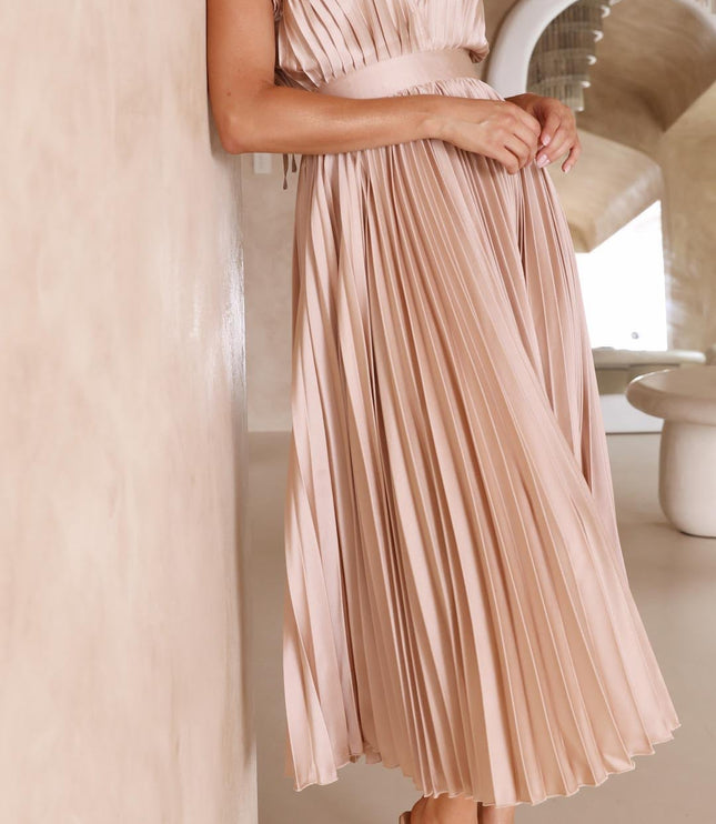 Women's light pink pleated v-neck midi dress, with hands clasped, emphasizing the delicate pleats and sophisticated design.