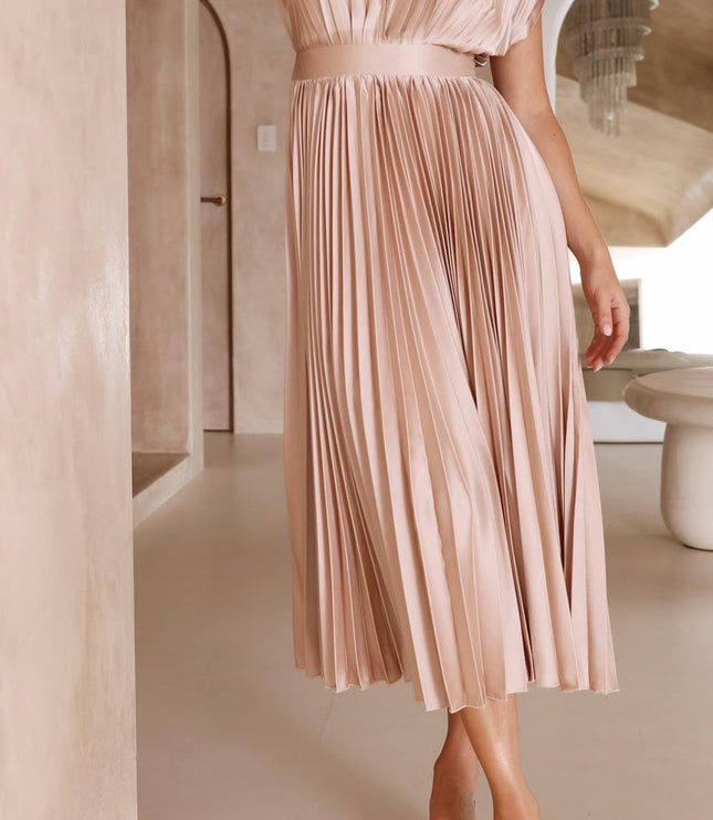 Side profile of a women's light pink pleated v-neck midi dress, highlighting the graceful flow of the skirt.