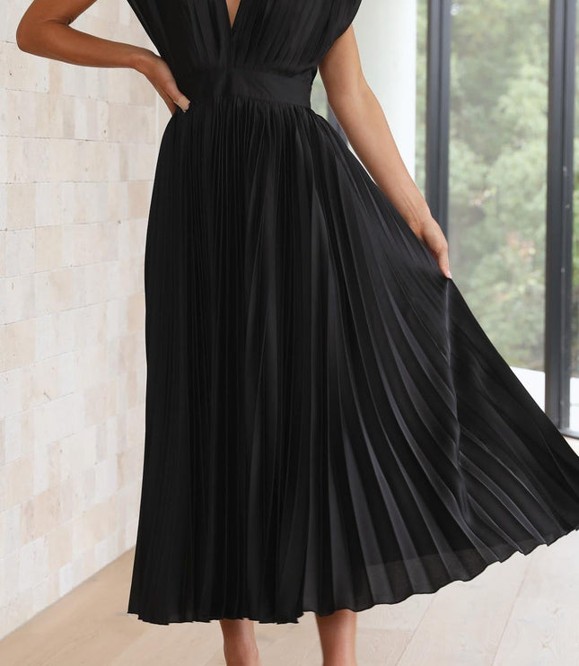 Dynamic view of the black pleated v-neck midi dress, with the model holding out the skirt to show its full pleats and movement.