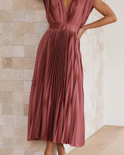 Side profile of a women's rose pleated v-neck midi dress, showcasing the flowing skirt and fitted bodice.