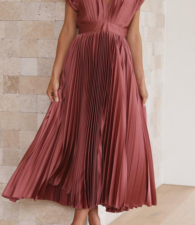 Full length view of a women's rose pleated v-neck midi dress, with the skirt gently fanned out, paired with nude heels.