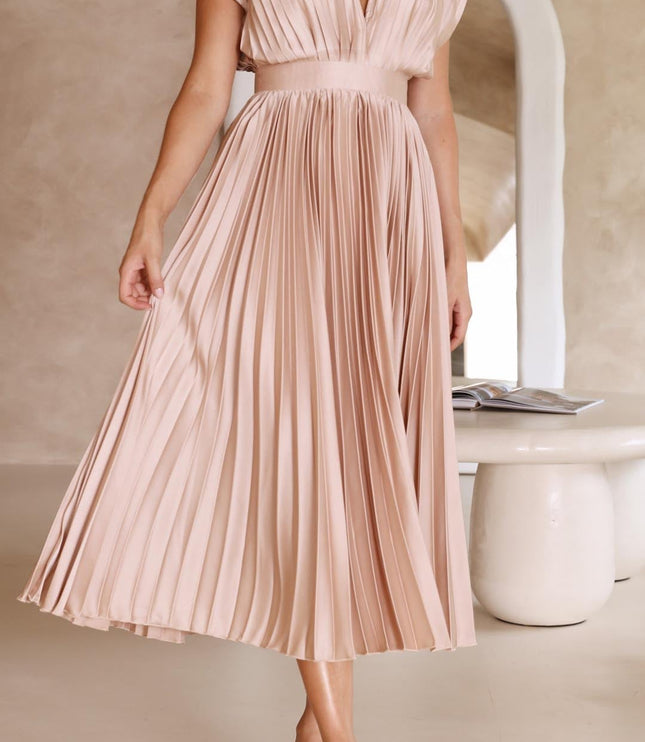 Full length view of a women's light pink pleated v-neck midi dress, showcasing the elegant silhouette and soft fabric.