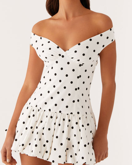 Close-up front view of white polka dot off-shoulder mini dress, highlighting the ruched bodice and sweetheart neckline.