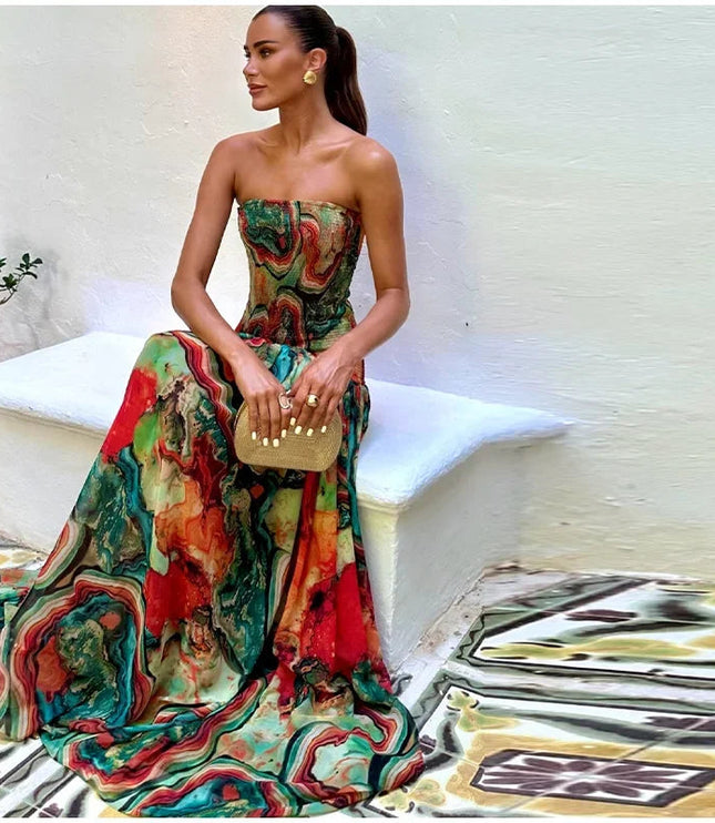 Side view of a woman wearing a strapless printed maxi dress with a gold clutch, highlighting the dress's full skirt.