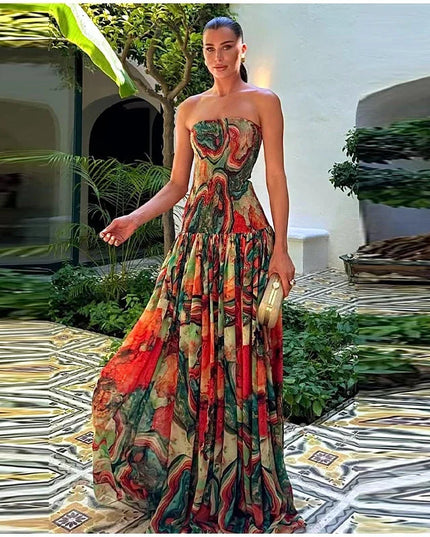 Full-length view of a woman standing in a strapless printed maxi dress with a vibrant, flowing design.