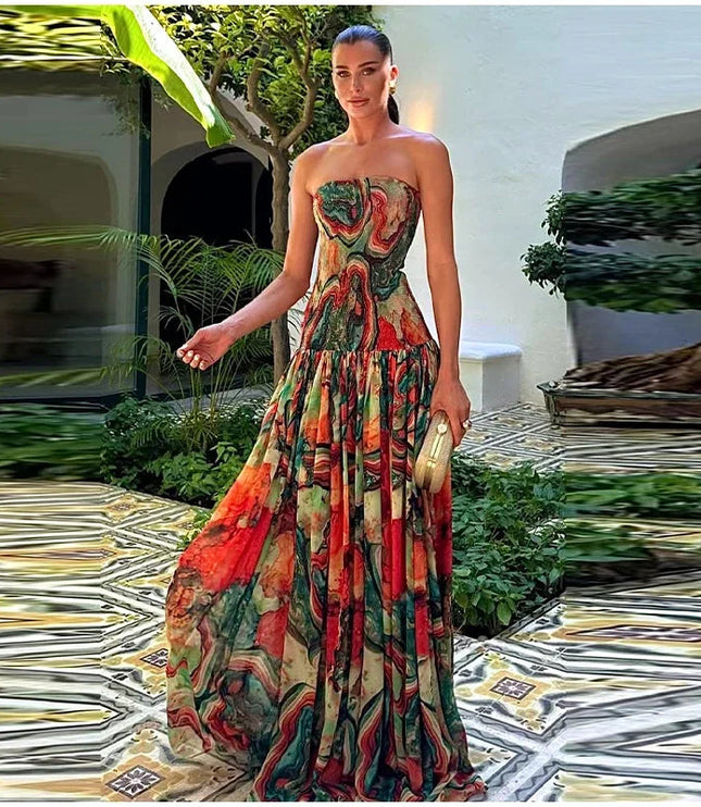 Full-length view of a woman standing in a strapless printed maxi dress with a vibrant, flowing design.