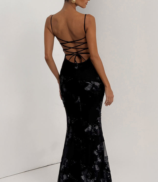 Back view of a black floral maxi dress with delicate spaghetti straps and a criss-cross lace-up corset back.