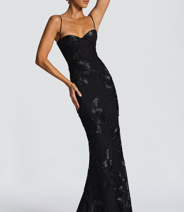 Side profile of a black floral maxi dress with intricate floral appliques and a silhouette, for prom.